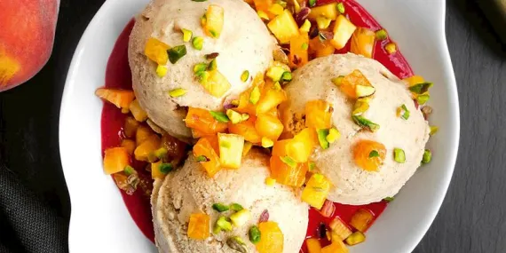 Hurmalı vanilyalı dondurma, ılık frambuaz sosu ve şeftali ile