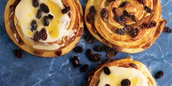 Krem peynir glazürlü ve kuru üzümlü kıvrımlar